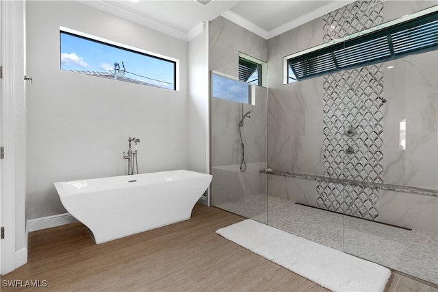 bathroom with a marble finish shower, baseboards, a soaking tub, wood finished floors, and crown molding