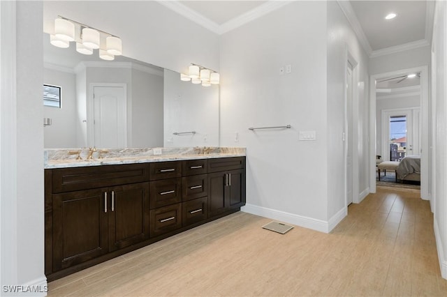 ensuite bathroom featuring ornamental molding, baseboards, and wood finished floors