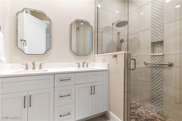 full bath featuring a stall shower, a sink, and double vanity