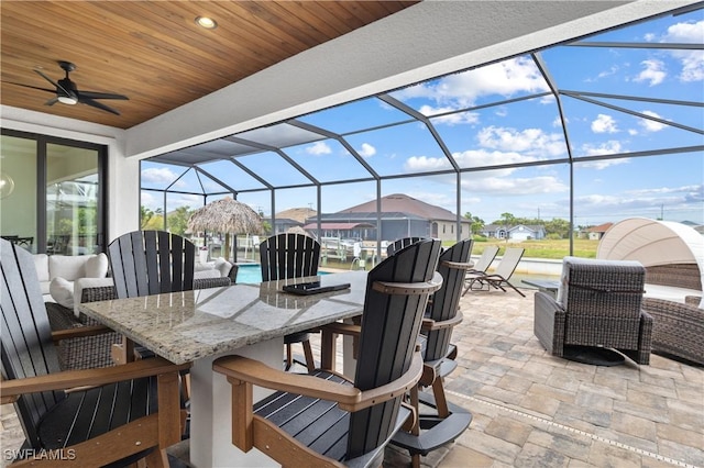 view of patio / terrace with glass enclosure, ceiling fan, and outdoor dry bar