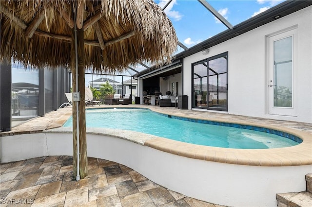 outdoor pool with a lanai, a patio area, and an outdoor living space