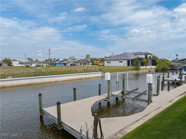 view of dock with a water view, a yard, and boat lift