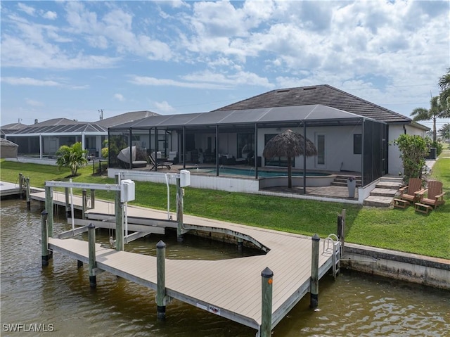 dock area with an outdoor pool, glass enclosure, a water view, and a yard