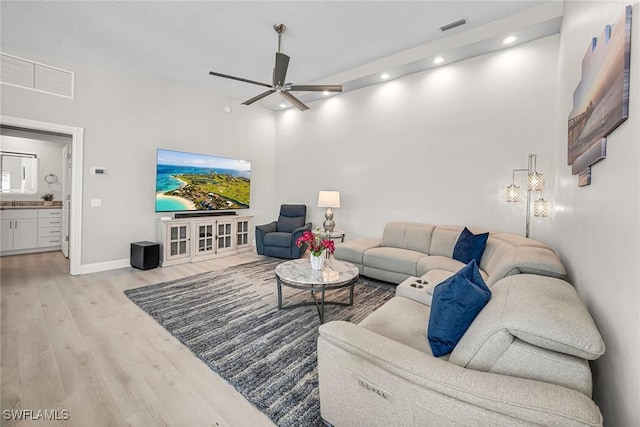 living area with a ceiling fan, recessed lighting, visible vents, and light wood-style floors