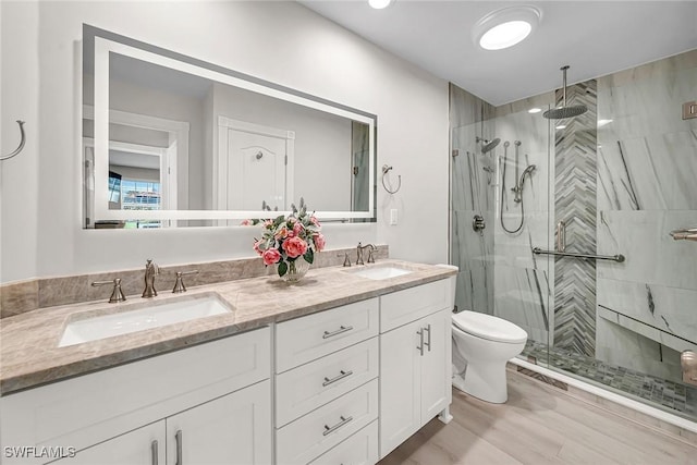 bathroom featuring double vanity, a shower stall, and a sink