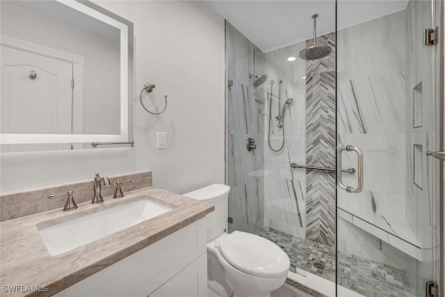 bathroom featuring a stall shower, vanity, and toilet