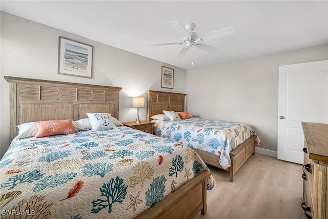 bedroom featuring a ceiling fan, light wood-type flooring, and baseboards