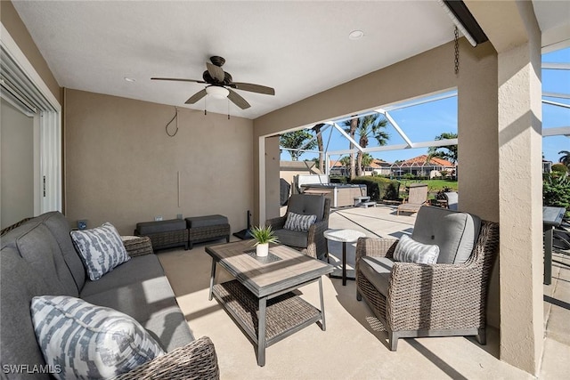 view of patio with a ceiling fan, glass enclosure, and outdoor lounge area