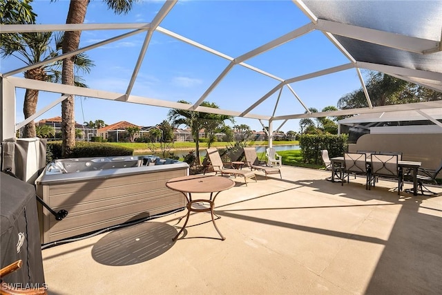 view of patio / terrace featuring a water view, glass enclosure, a hot tub, and outdoor dining space