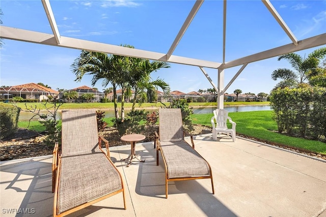 view of patio with a water view and glass enclosure