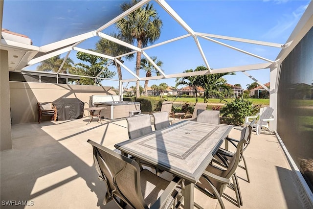 view of patio featuring outdoor dining space, a lanai, and a hot tub