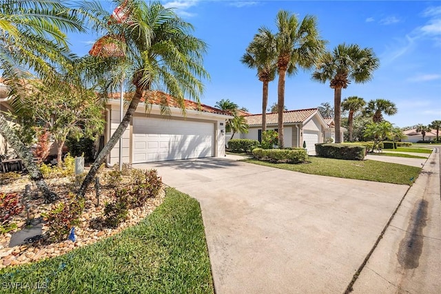 view of front of home featuring stucco siding, concrete driveway, an attached garage, a tiled roof, and a front lawn