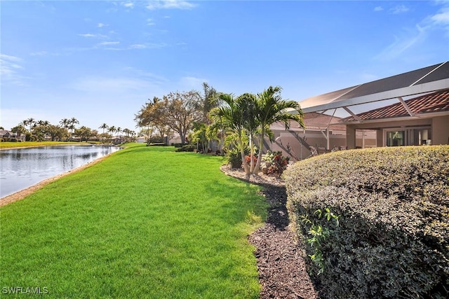 view of yard with a water view and a lanai