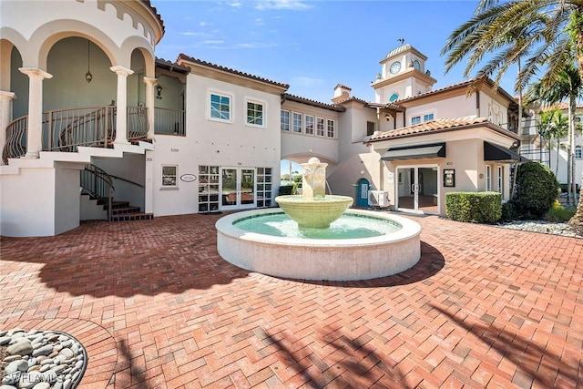 back of property featuring stucco siding, a chimney, stairway, and french doors