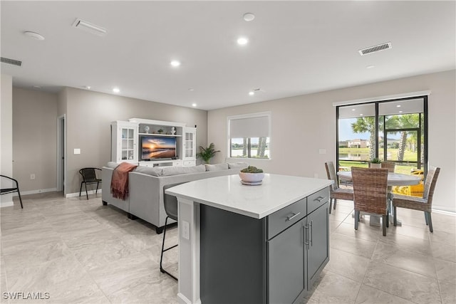 kitchen featuring light countertops, recessed lighting, visible vents, and a center island