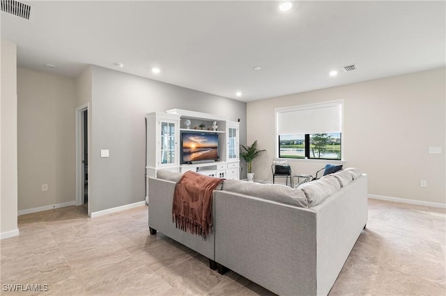 living room featuring baseboards, visible vents, and recessed lighting