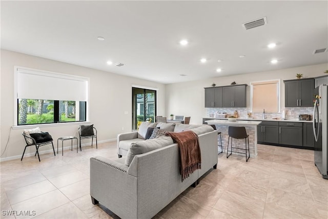living area featuring recessed lighting, visible vents, plenty of natural light, and baseboards