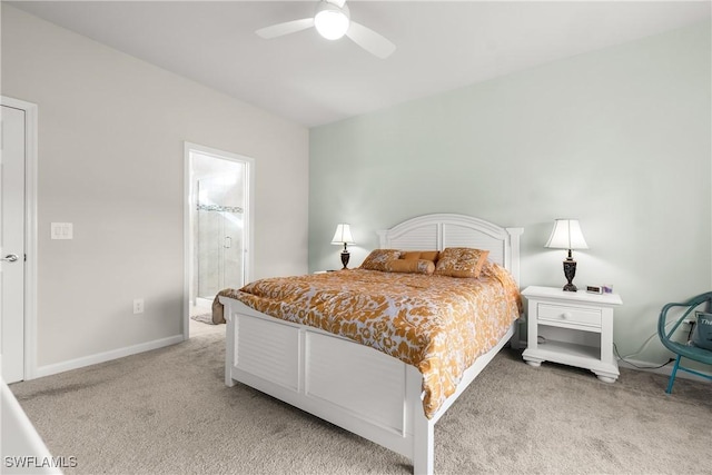 bedroom featuring baseboards, ensuite bathroom, a ceiling fan, and light colored carpet