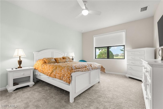 bedroom with a ceiling fan, light colored carpet, visible vents, and baseboards