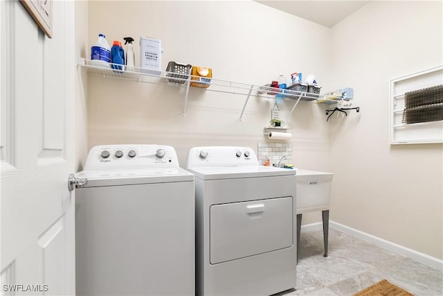 washroom with laundry area, baseboards, and independent washer and dryer