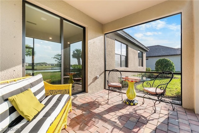 sunroom featuring a wealth of natural light and a water view