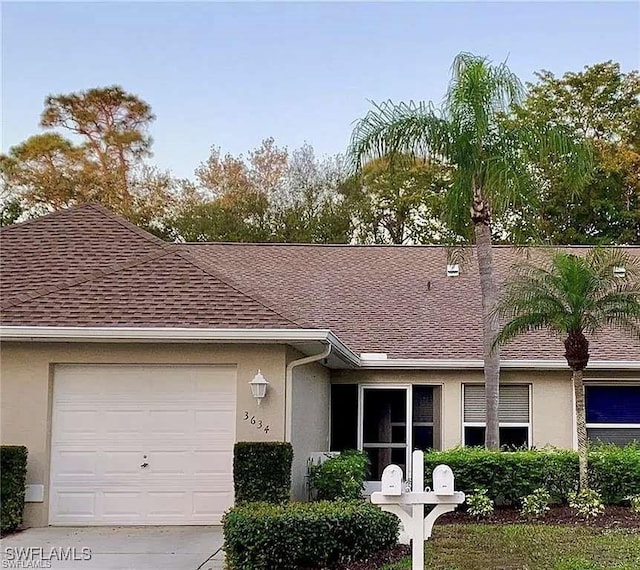 ranch-style home featuring a shingled roof, an attached garage, and stucco siding