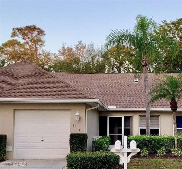 ranch-style home featuring stucco siding, a garage, and roof with shingles