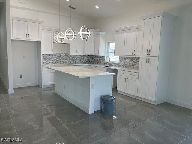 kitchen featuring decorative backsplash, lofted ceiling, white cabinets, and a kitchen island