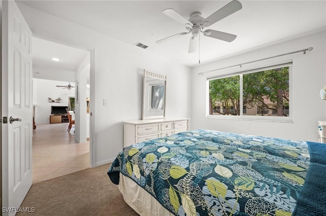 bedroom with light carpet, baseboards, visible vents, a ceiling fan, and light tile patterned flooring