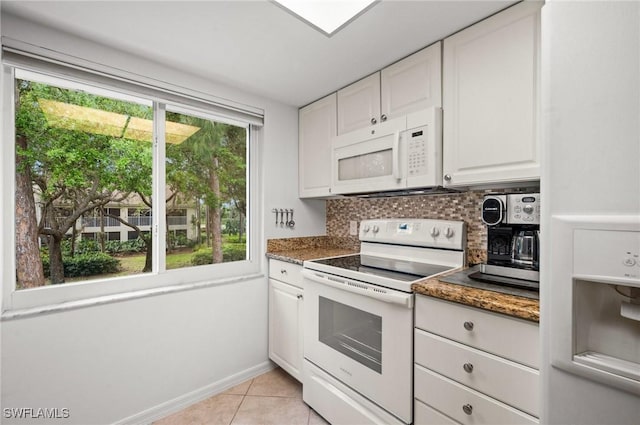 kitchen featuring white appliances, a healthy amount of sunlight, decorative backsplash, and light tile patterned floors