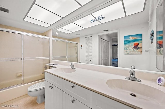 full bathroom featuring toilet, a skylight, double vanity, and a sink