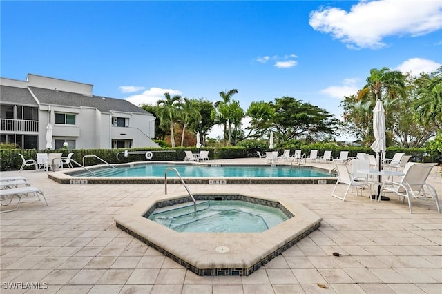 community pool featuring a patio and a hot tub