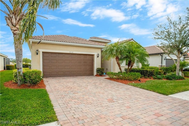 view of front facade featuring stucco siding, an attached garage, a tile roof, and decorative driveway