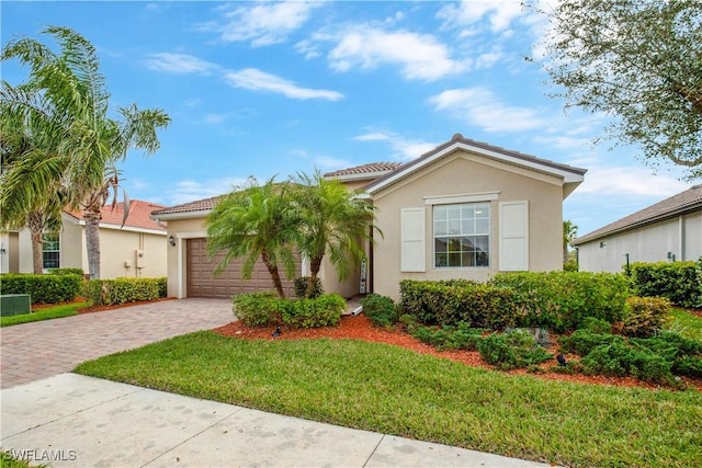 view of front of house with decorative driveway, a front yard, an attached garage, and stucco siding