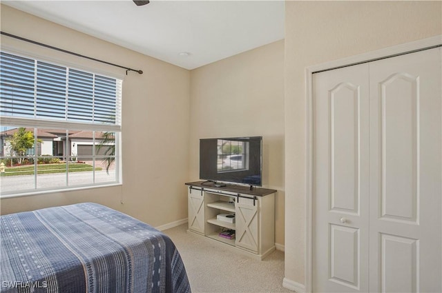 bedroom with light colored carpet and baseboards