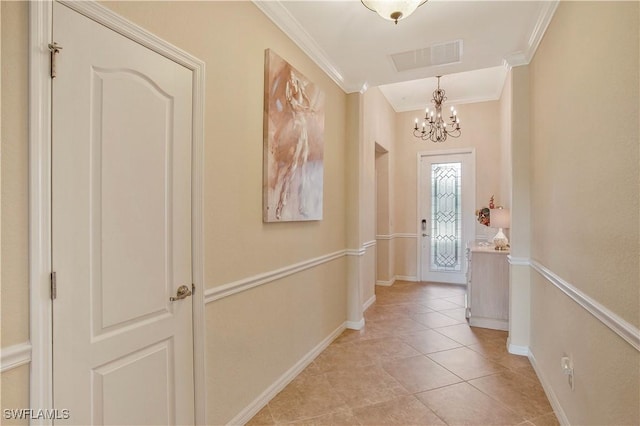 doorway featuring visible vents, baseboards, an inviting chandelier, and crown molding