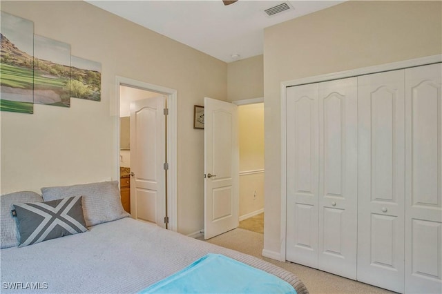 bedroom featuring a closet, visible vents, light colored carpet, and baseboards