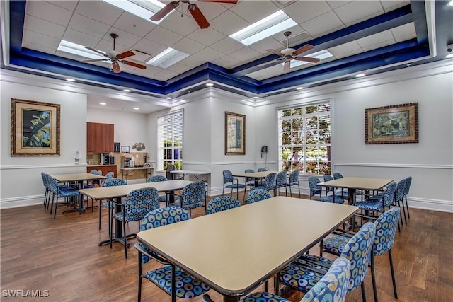 dining room featuring baseboards, a raised ceiling, and wood finished floors