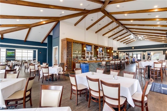 dining area featuring beam ceiling and high vaulted ceiling