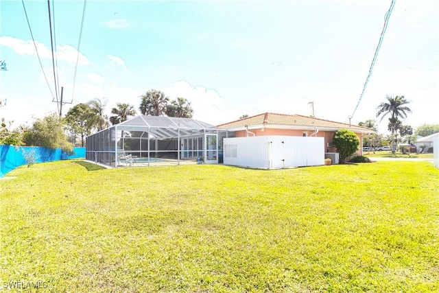 view of yard featuring glass enclosure, central AC, and fence