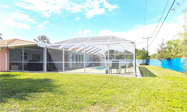 back of house with a fenced in pool, a patio, a lawn, a lanai, and a fenced backyard