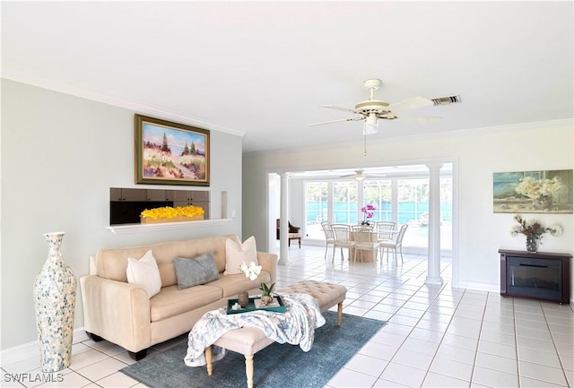 living area with light tile patterned floors, visible vents, baseboards, ornamental molding, and decorative columns