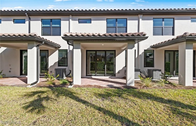 back of house featuring stucco siding, a yard, central AC unit, and a patio