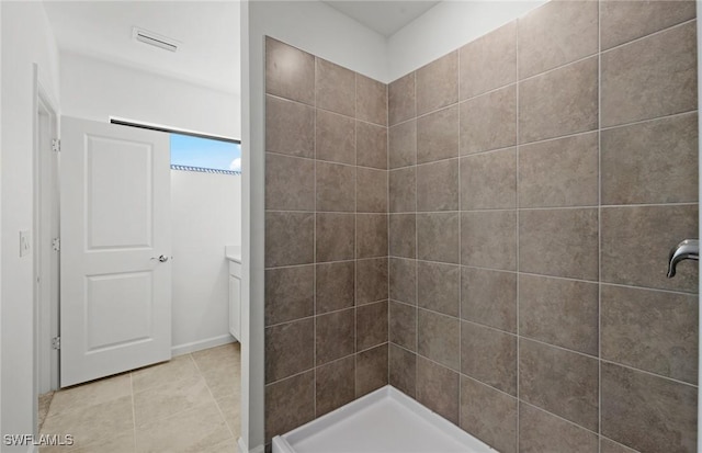 bathroom with tiled shower, visible vents, and tile patterned floors