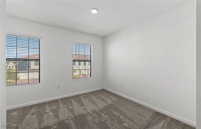 unfurnished room featuring carpet flooring and baseboards