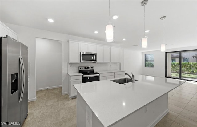 kitchen featuring stainless steel appliances, light countertops, a sink, and decorative backsplash