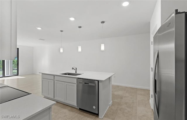 kitchen with stainless steel appliances, a sink, light countertops, and pendant lighting