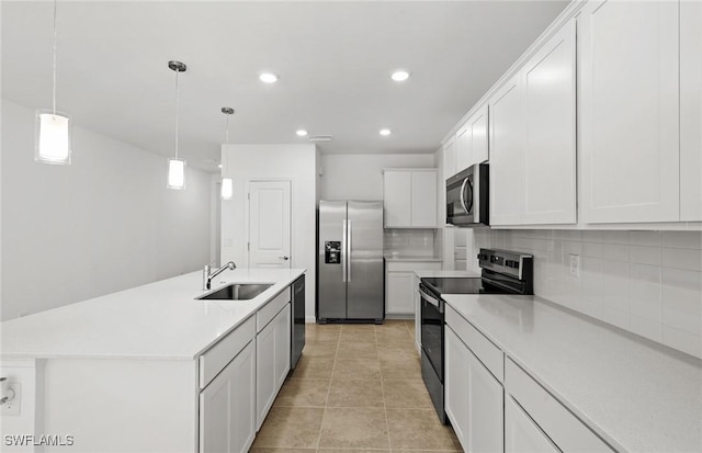 kitchen with stainless steel appliances, tasteful backsplash, light tile patterned flooring, a sink, and white cabinetry