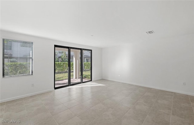 unfurnished room with visible vents and baseboards