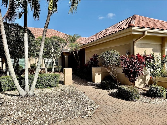 exterior space featuring a tiled roof and stucco siding